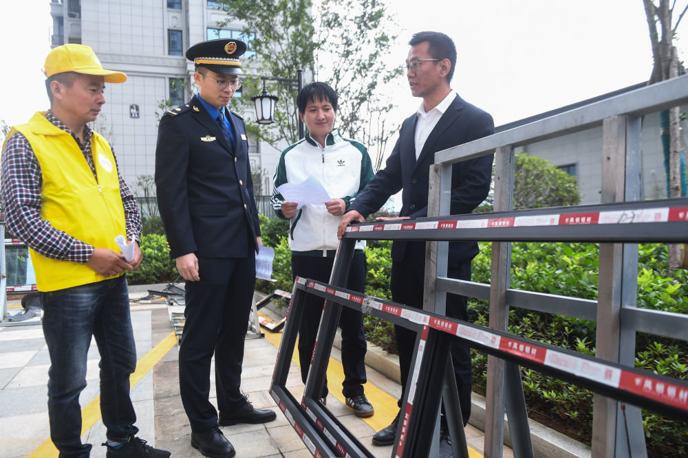 在浙江诸暨市枫桥镇一个新交付的小区内,诸暨市综合行政执法大队枫桥镇中队执法人员与红枫管家志愿者现场商讨小区统一装修规范(2021年10月19日摄)。新华社记者 徐昱 摄