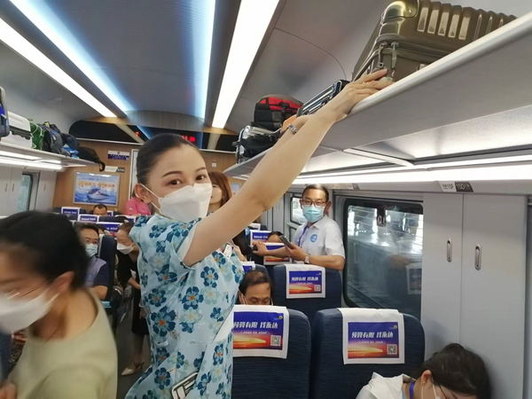 7月27日，列车长赵莹静在整理旅客的行李。新华网记者 侯强 摄