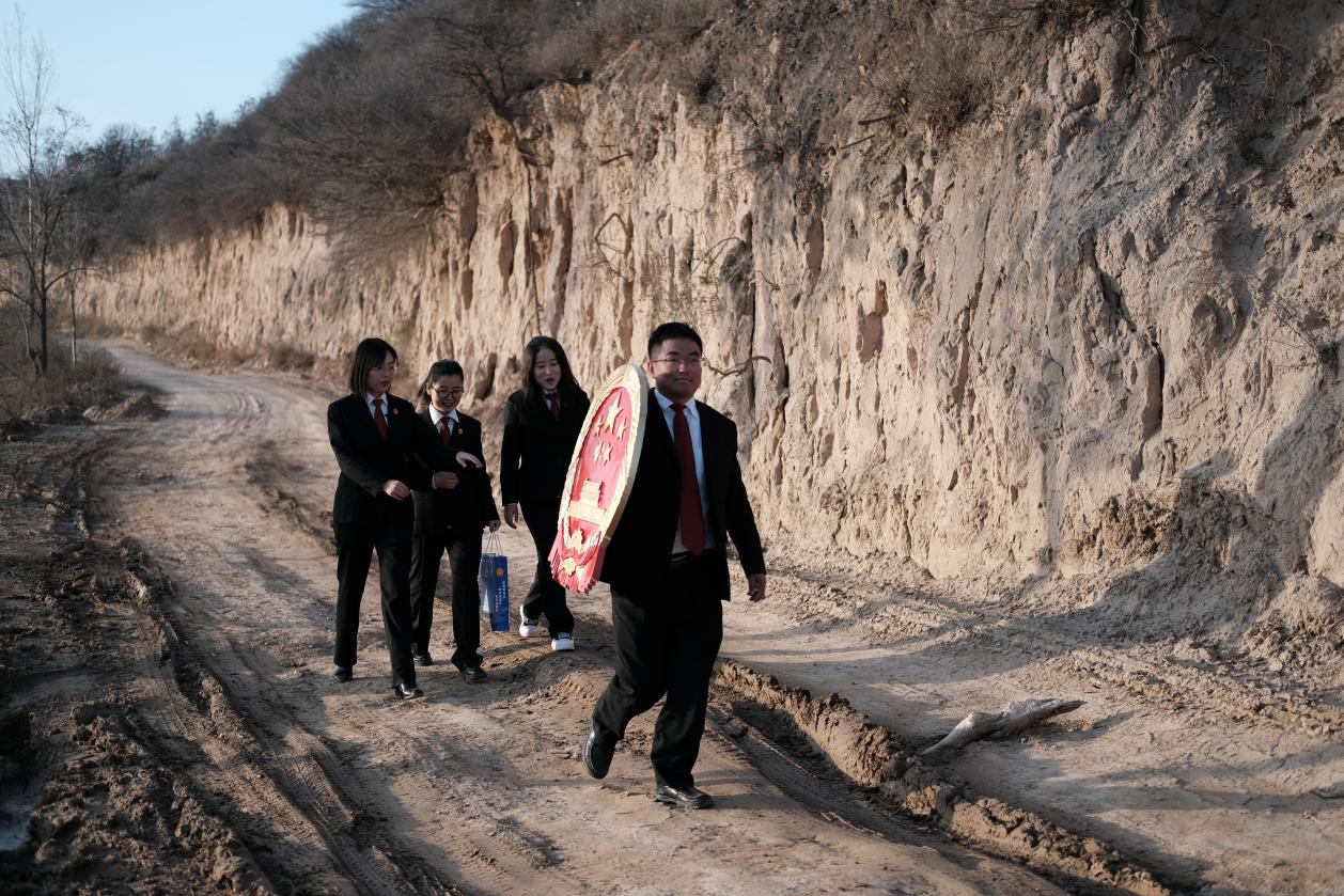 志丹县苹果巡回法庭的负责人张丽梅（左一）和同事们走进果园为果农宣讲法律政策，将法庭“搬到”田间地头。人民网记者 吴超摄
