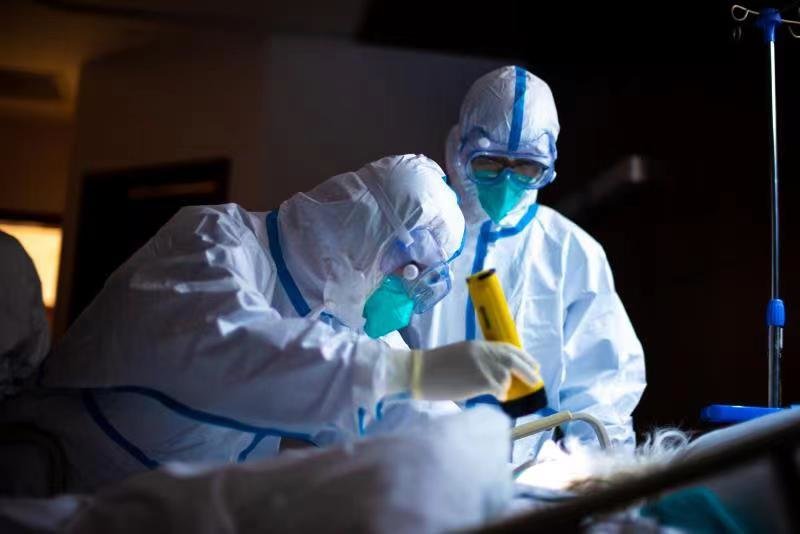 瑞金医院的医护人员夜间查房,查看昏迷重症病人的瞳孔反射