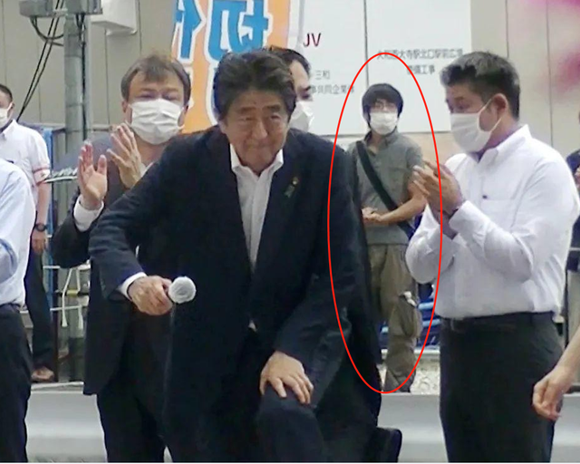 ▲安倍晋三遇刺前,枪手山上彻也站在其身后