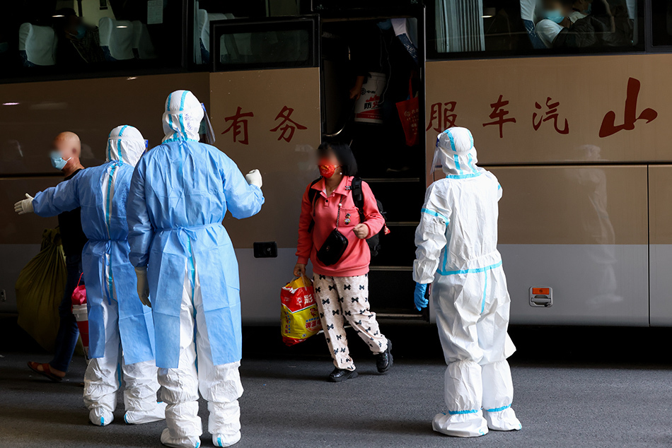 2022年4月9日12时许，穿着防护服的工作人员指引大家下车，有序进入国家会展中心（上海）方舱医院内。澎湃新闻记者 曹俊杰