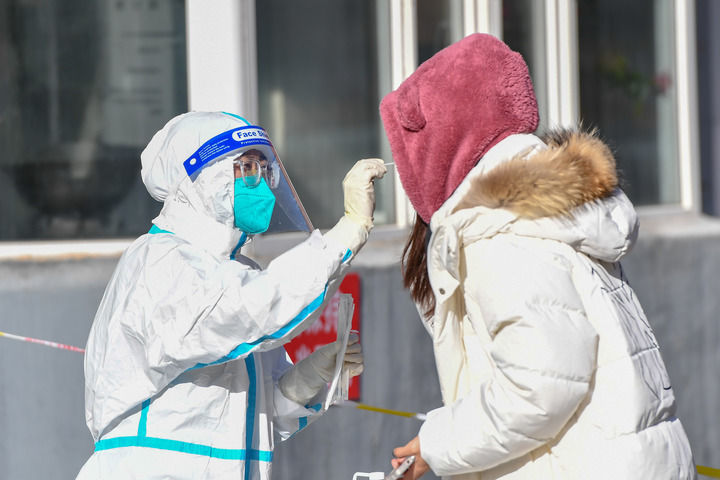 2022年3月11日，吉林市船营区大东街道一核酸检测采样点，工作人员为居民进行核酸检测采样。新华社记者张楠 摄