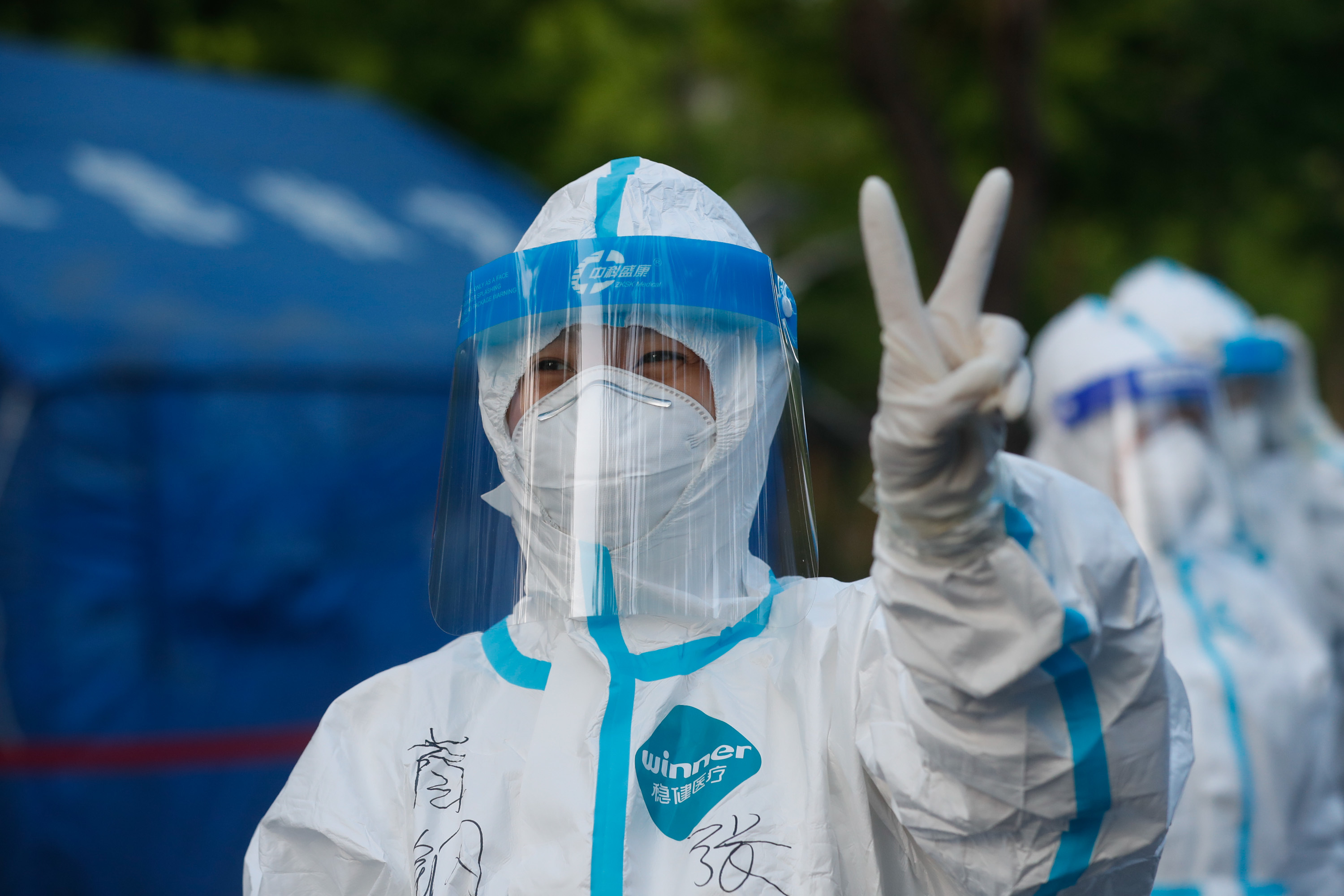 4月30日清晨6:24,苹果园办事处南侧采样点,医护人员比出"耶"的手势