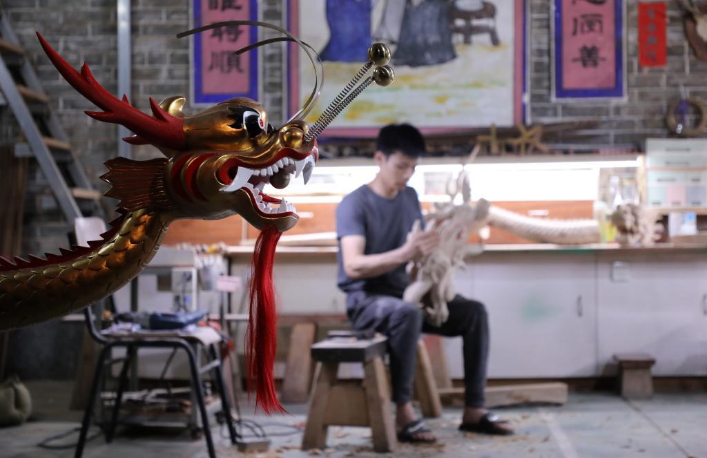 他是广州市黄埔区非遗项目"龙舟龙头,龙尾制作技艺"的代表性传承人