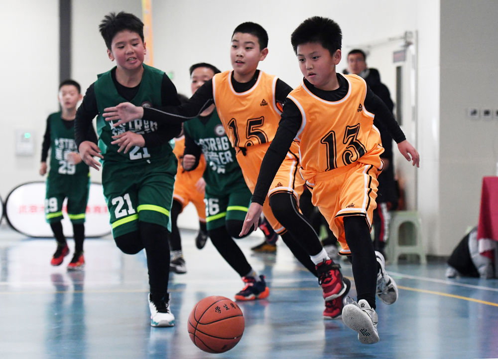 ↑怀柔区第三小学选手在2021年北京市第一届小学生篮球比赛中带球进攻（2021年12月11日摄）。