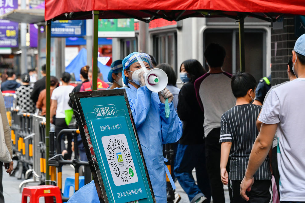 3月13日，志愿者在深圳罗湖区东门广场核酸检测点引导居民。新华社发（储焱摄）