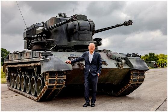 路透社发布图片：朔尔茨8月时视察军事基地时与“猎豹”防空坦克合影。