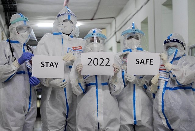 2021年12月31日,在印度班加罗尔的一所医院,医务人员拿着写有“2022”和“保持安全”字样的纸张。(文内配图均为新华社资料)