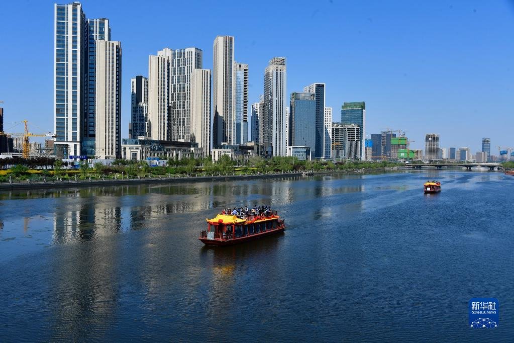 游船驶过位于北京市通州区的运河商务区(2020年4月26日摄,无人机照片)。新华社发(常鸣 摄)