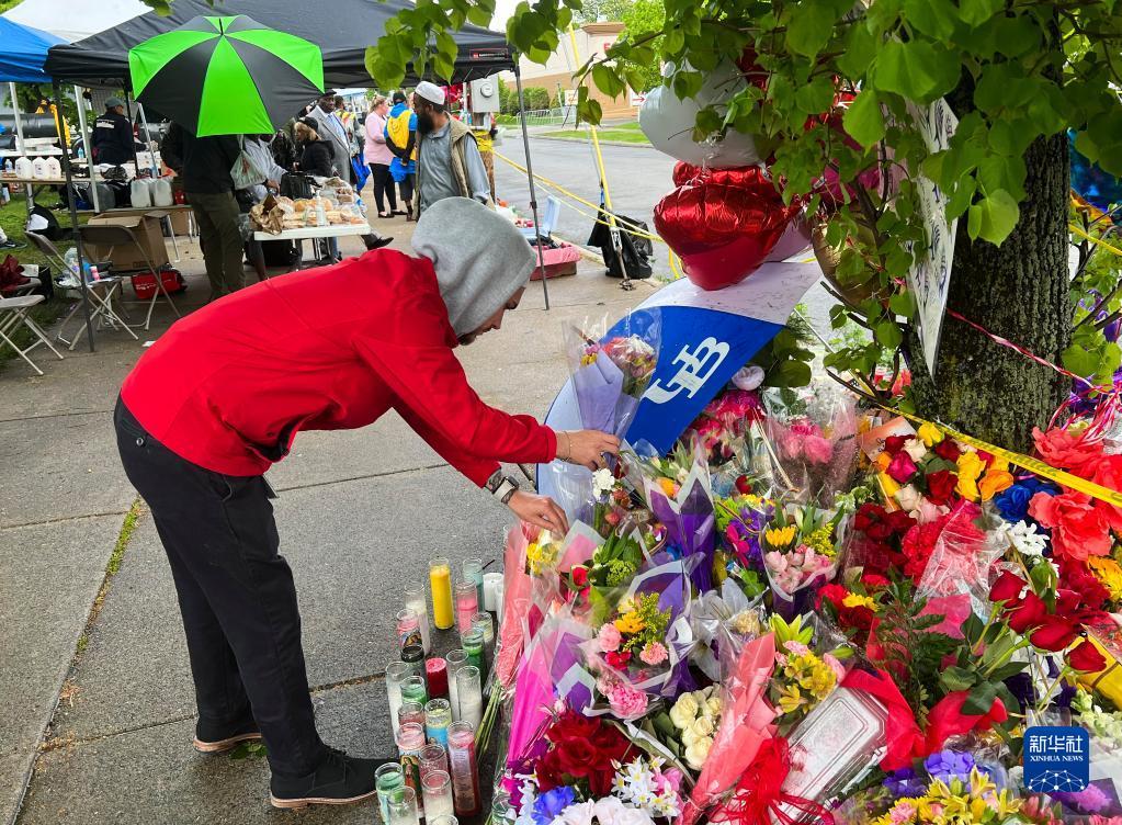 5月16日，在美国纽约州布法罗市，一名男子摆放花束悼念枪击事件遇难者。美国纽约州布法罗市一家超市14日发生枪击事件，造成至少10人死亡、3人受伤。新华社发（张杰 摄）