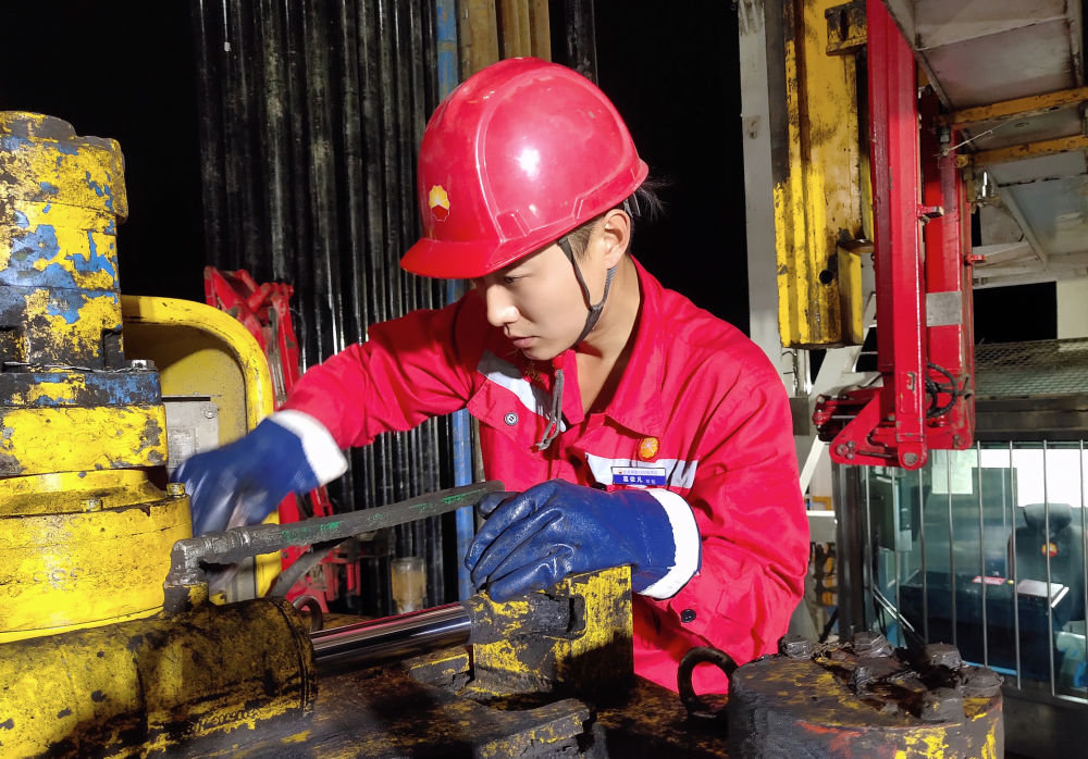 10月17日,黑龙江大庆油田1205钻井队青年员工葛依凡在作业中。新华社发(段永坚 摄)