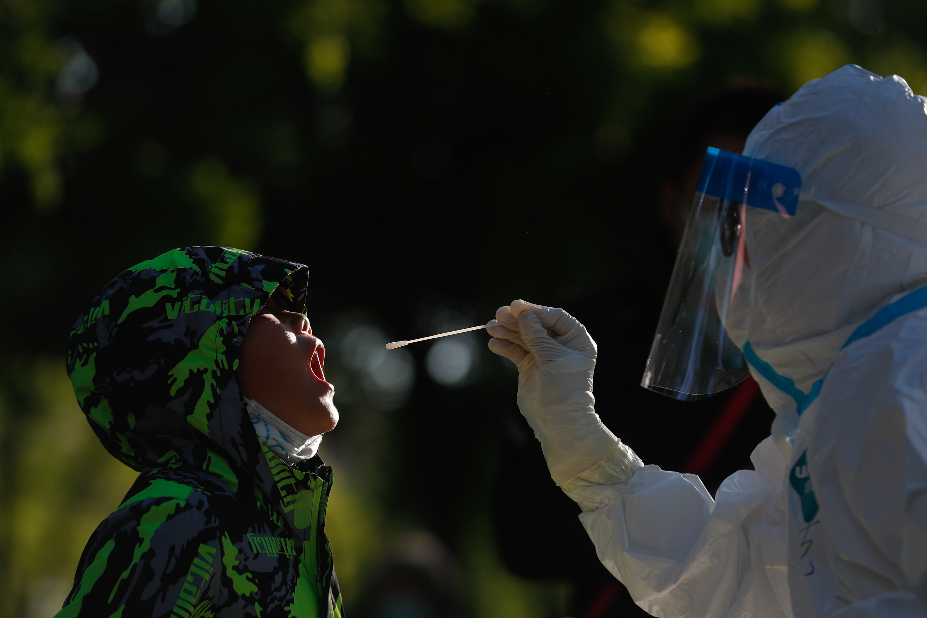 4月30日清晨,苹果园办事处南侧采样点,小朋友张大嘴巴接受核酸检测.