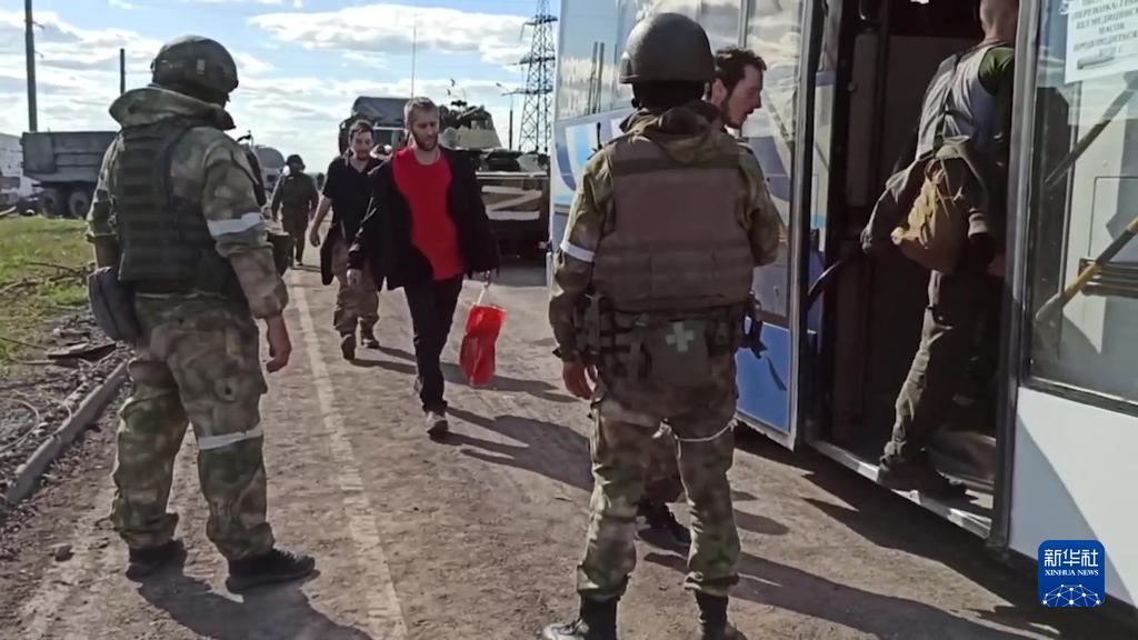 5月16日，在马里乌波尔，乌克兰士兵登上一辆由俄军士兵守卫的汽车。