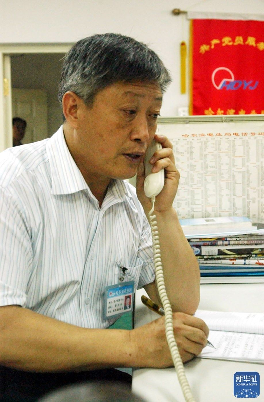 李庆长在接听求助电话(2004年7月1日摄)。新华社记者 李勇 摄