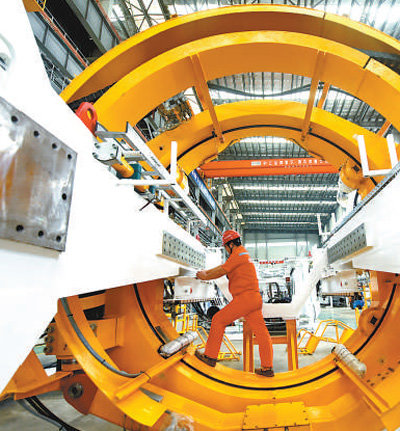 浙江中铁装备盾构机生产基地，工人在安装新型盾构机的部件。