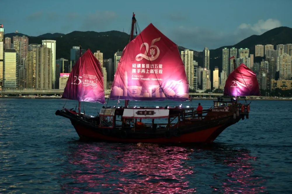 2022年6月23日，一艘挂着庆祝香港回归祖国25周年横幅的帆船在香港维多利亚港航行 卢炳辉摄 / 本刊