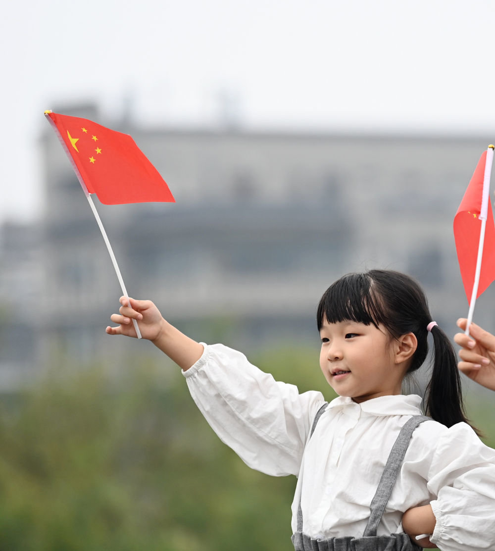 △10月1日，小游客在西安城墙景区挥舞国旗。