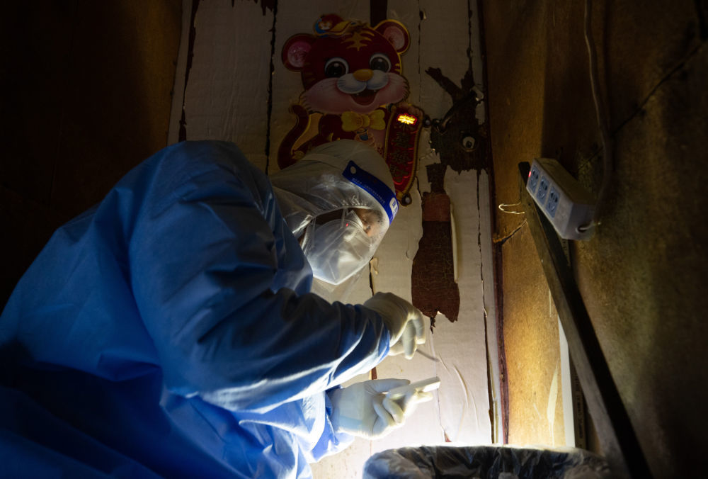 ↑4月5日,广福居委会工作人员袁勇军在已经确诊为阳性的赵女士的家门口装上门磁。