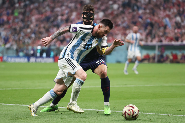 12月13日，阿根廷队球员梅西（前）与克罗地亚队球员格瓦迪奥尔在比赛中拼抢。新华社记者 兰红光 摄