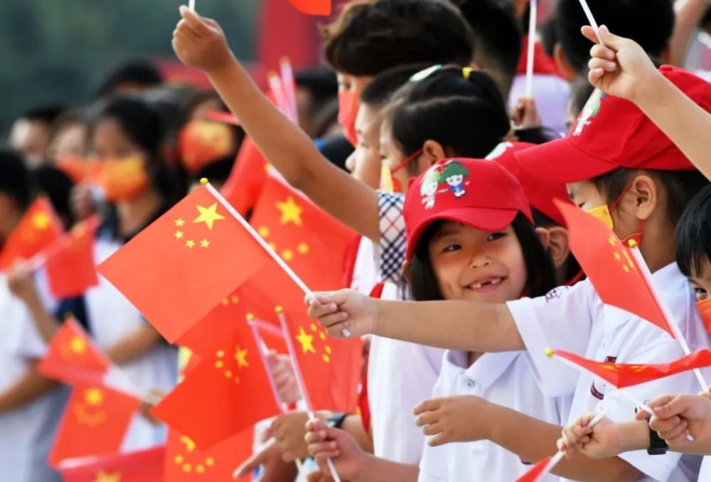 资料图:2021年10月1日,市民在青岛举行的国庆升旗仪式上挥舞国旗。新华社记者 李紫恒 摄