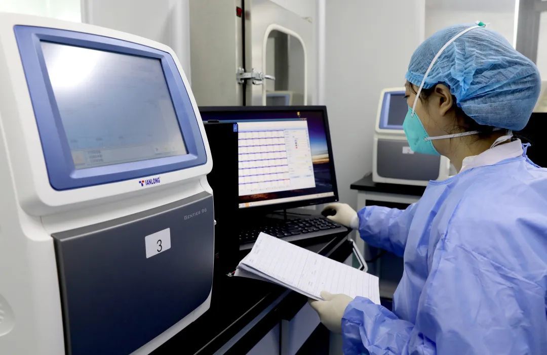 5 月 23 日，四川省华蓥市，一位工作人员在实验室内分析核酸检测结果，出具报告 图源：IC Photo