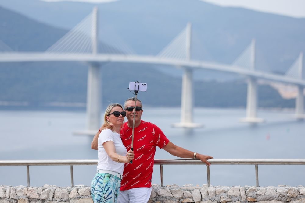 7月27日,民众在克罗地亚科马尔纳与新通车的佩列沙茨大桥合影。新华社发(Pixsell图片社,伊戈尔·克拉利摄)