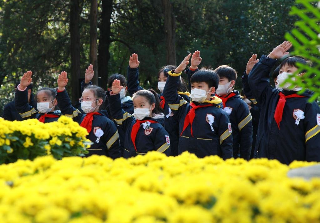 2021年12月13日,少先队员在侵华日军南京大屠杀北极阁附近遇难同胞纪念碑前行少先队队礼。新华社发(刘建华 摄)