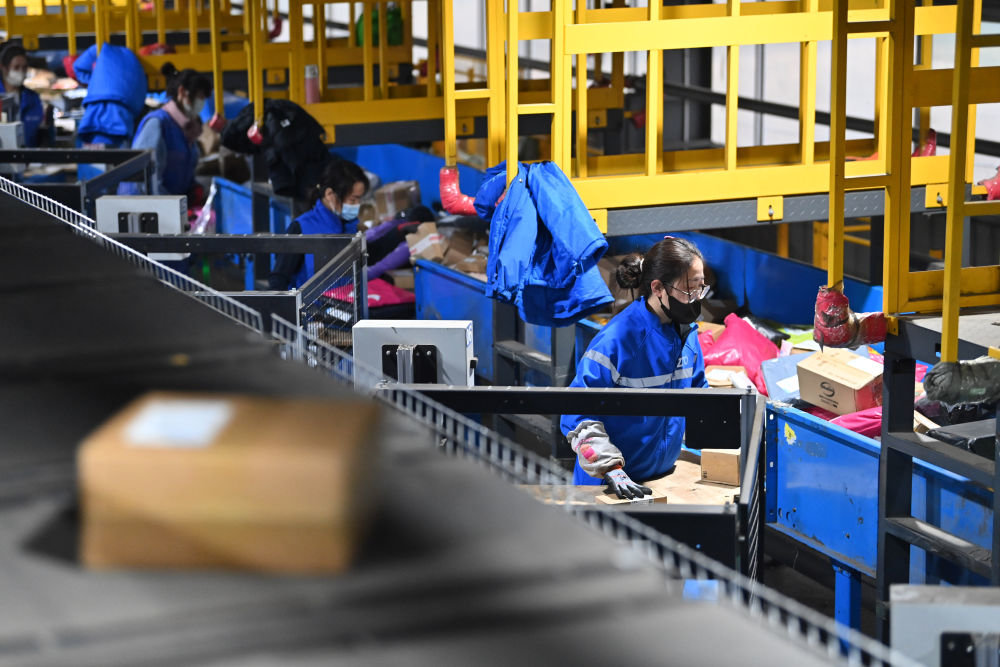 11月11日,在山西太原一家快递企业的转运中心,工作人员在分拣包裹