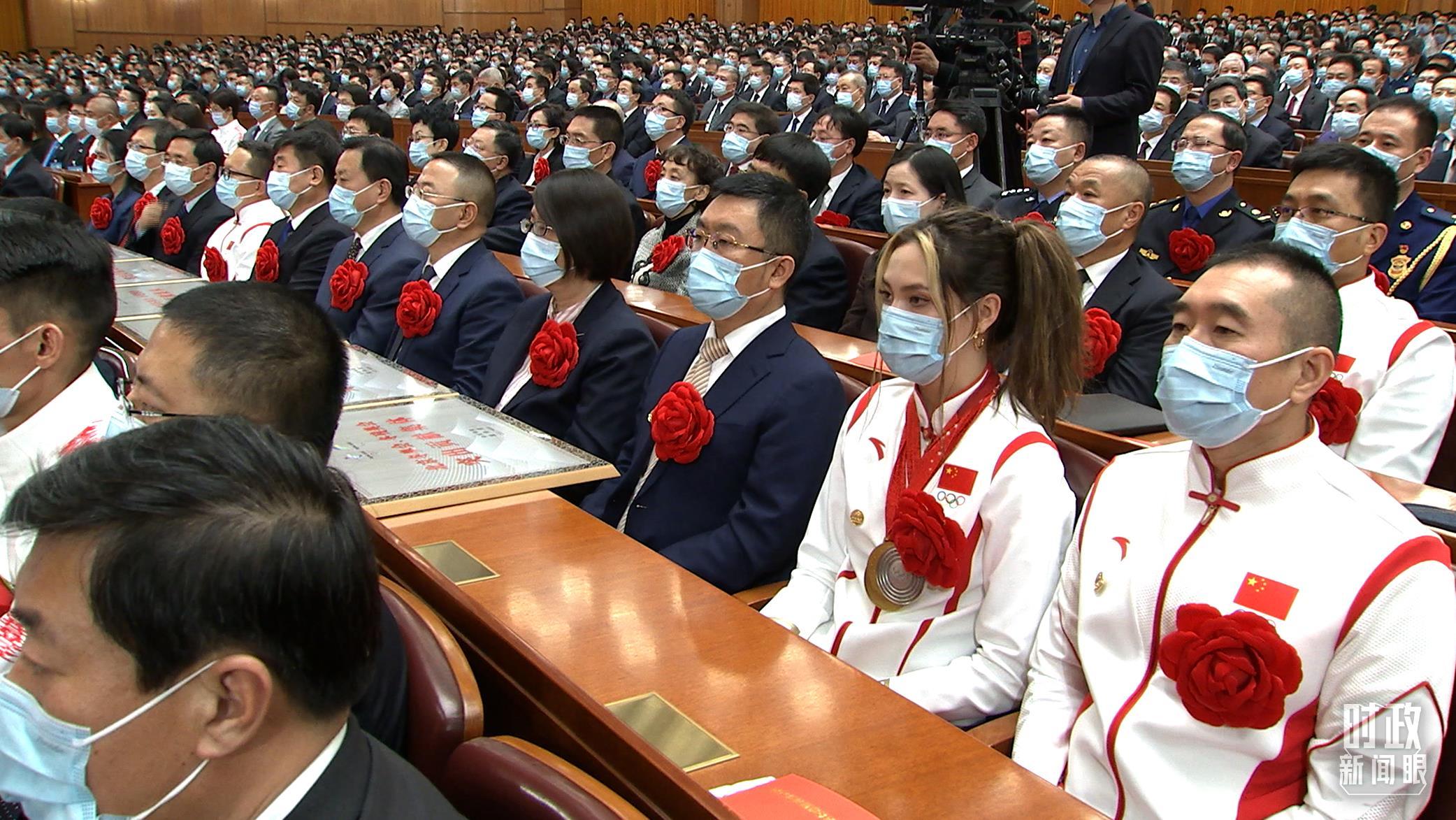 △习近平当天在大会上亲切地说：“谷爱凌爱吃馅饼”，现场笑声与掌声一片。右二为谷爱凌。（总台央视记者杨立峰拍摄）