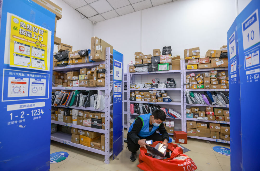6月18日,在浙江杭州一处快递驿站,一名收揽件工作人员正在整理入站的