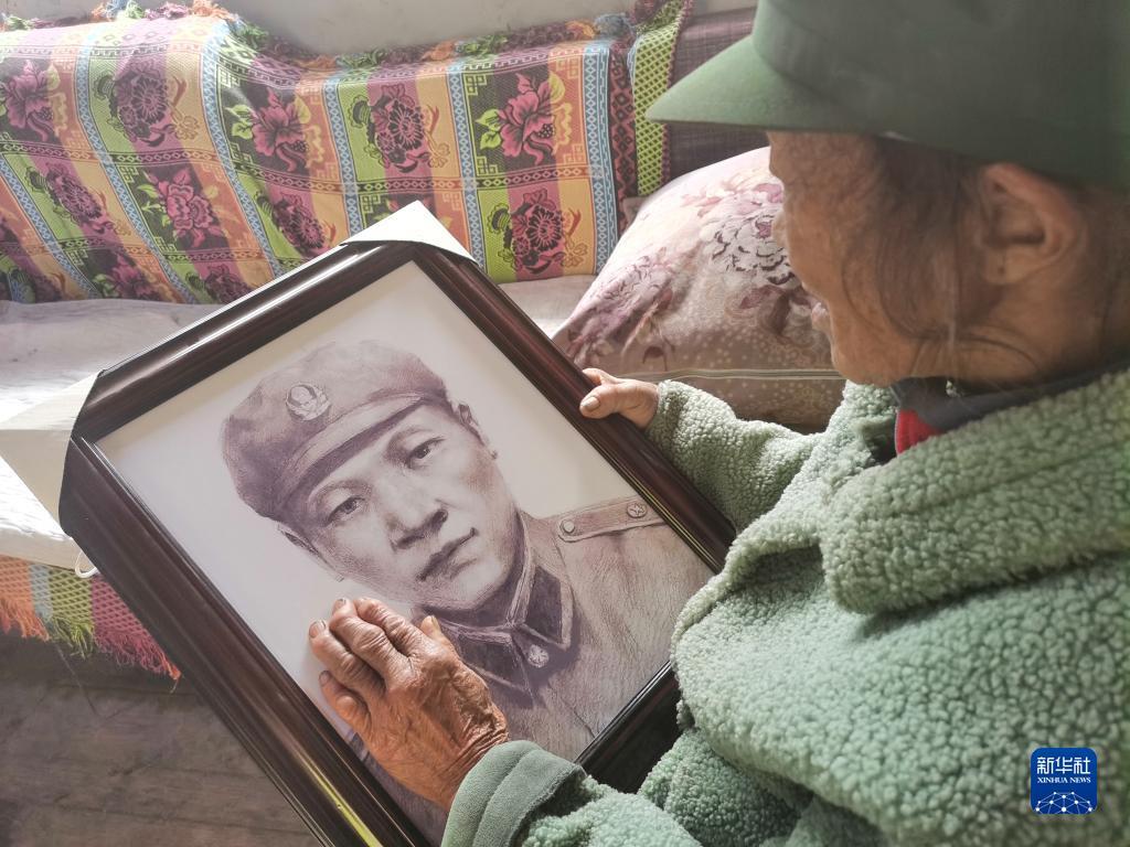 当独龙江边境派出所将画好的齐当此烈士照片送到遗孀齐秀珍手中时