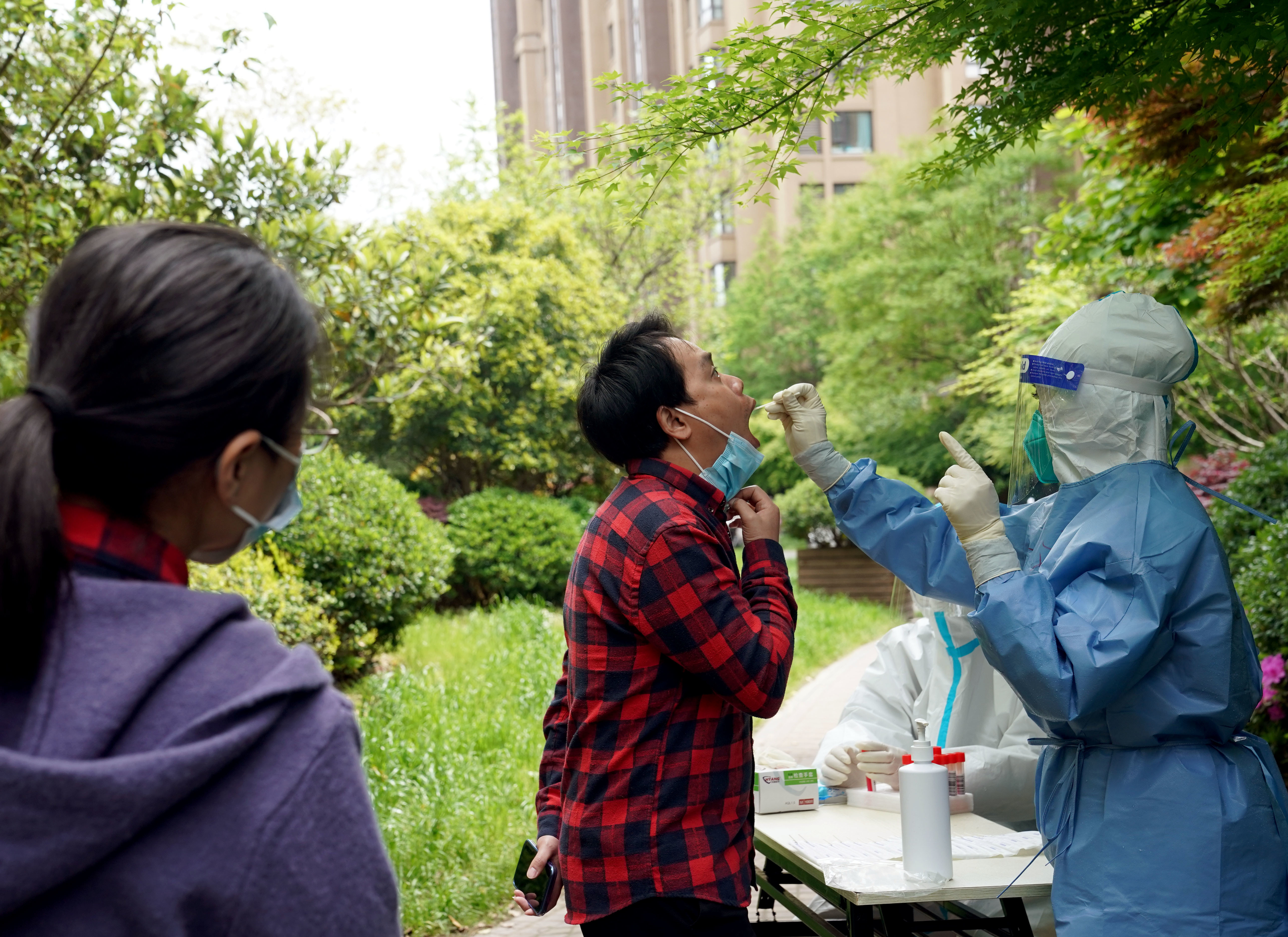 4月16日，在上海市松江区一个被列为封控区的小区内，居民在接受核酸检测采样。新华社记者 刘颖 摄