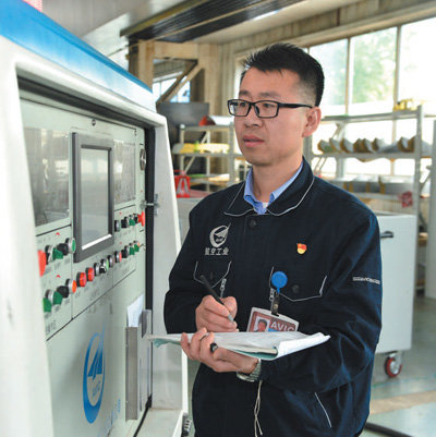 孙志强在记录设备加工数据。