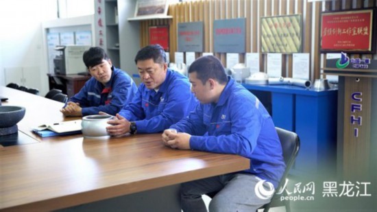 刘伯鸣（中）在劳模工匠创新工作室与团队讨论锻造工艺。人民网 苏靖刚摄