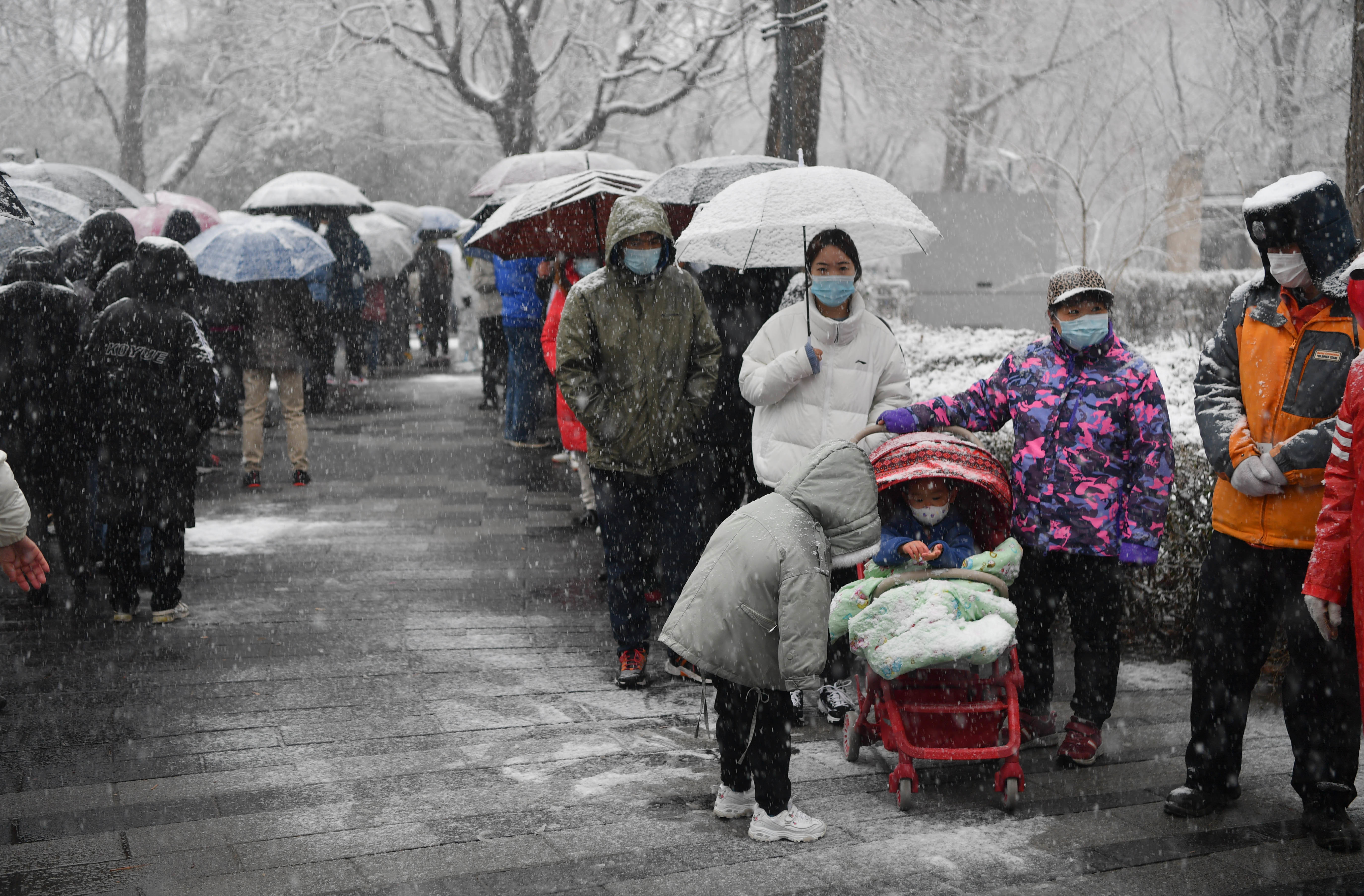 东城封控小区居民开展核酸检测大白贴暖宝大雪中值守