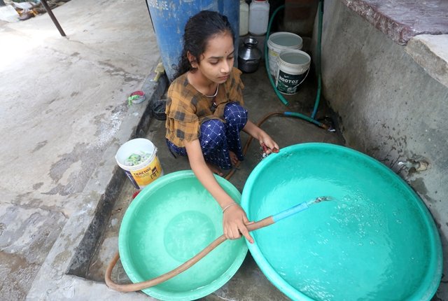 新开发银行为印度政府提供贷款,改善中央邦多个村庄的供水系统。图为女孩在中央邦博帕尔戈拉村通过水管打水。