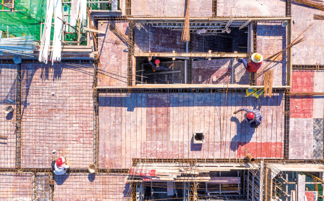 图｜2022年7月6日，四川南充的一处工地上，建筑工人顶着烈日在楼顶拴钢筋