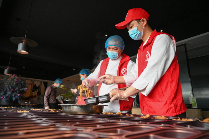 3月18日，志愿者在泉州市一家餐饮店内分装爱心午餐。新华社记者 周义 摄