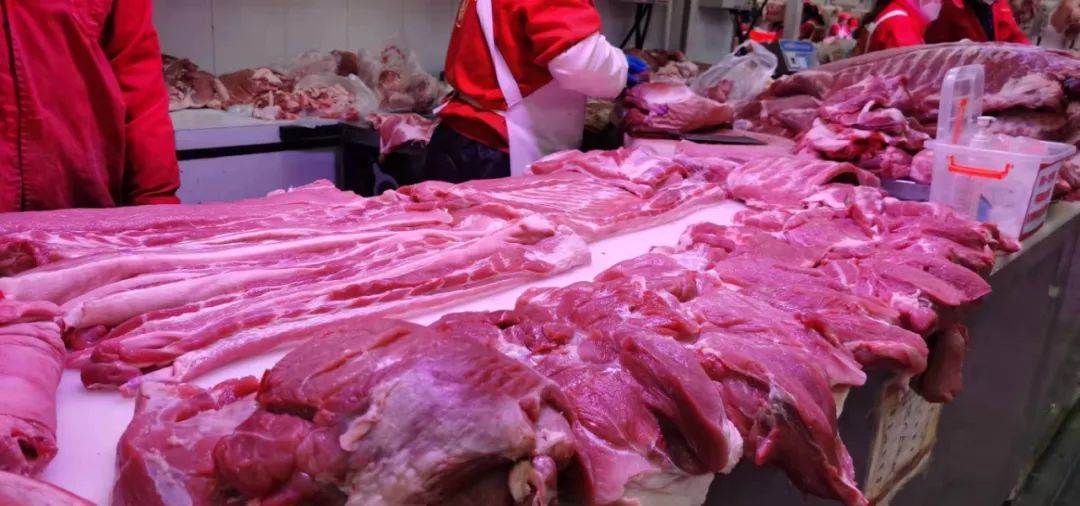 ▲新发地市场肉类交易大厅,商户在切割猪肉。摄影/新京报记者 王思炀