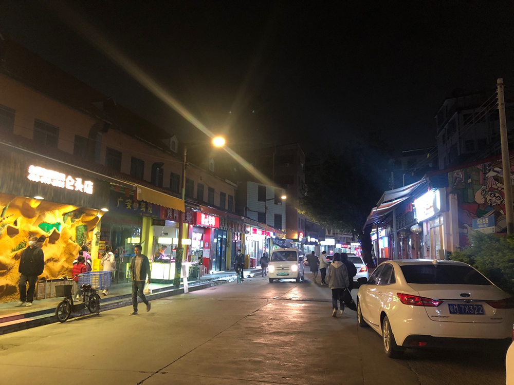 “解封”后,仑头村恢复了生活秩序。12月5日晚,不少人在村口的小街行走、吃饭。澎湃新闻记者 陈绪厚 图