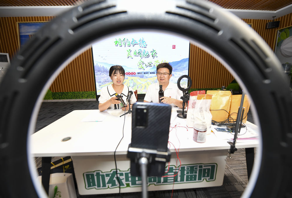 帮扶干部（右）和村民在宁夏吴忠市红寺堡区弘德村直播带货（6月23日摄）。 新华社记者 冯开华 摄