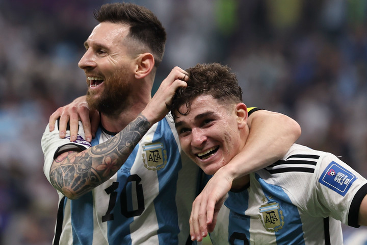 12月13日，阿根廷队球员阿尔瓦雷斯（右）在比赛中进球后与队友梅西庆祝。新华社记者 徐子鉴 摄