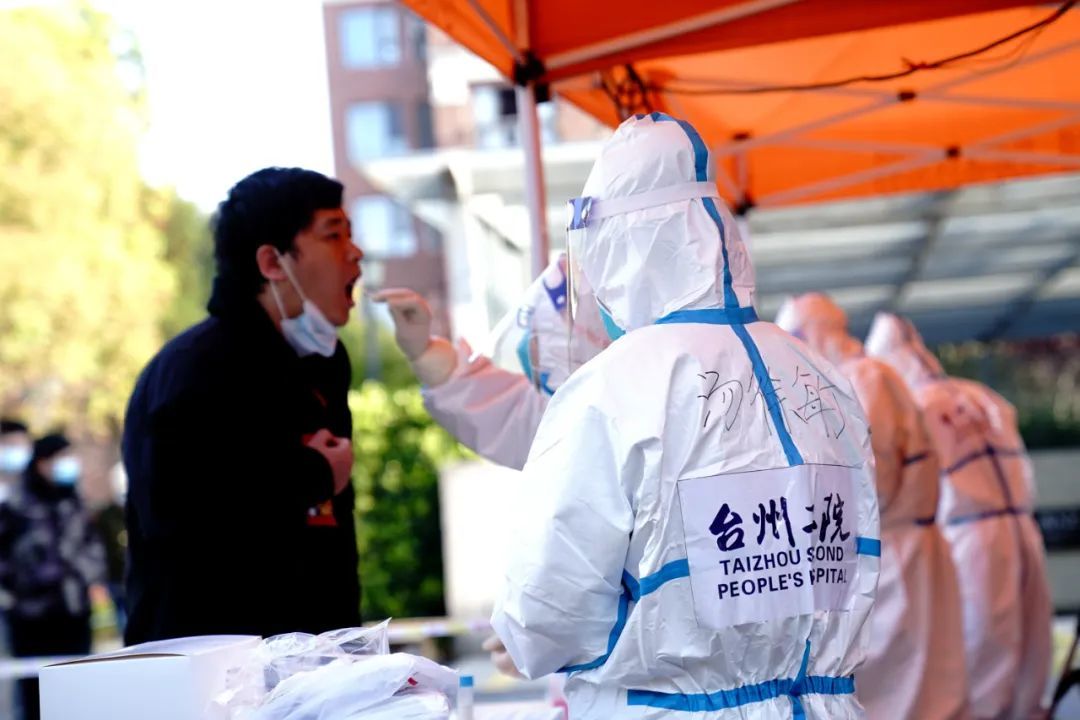 4月4日,来自浙江台州二院的援沪人员为松江区洞泾镇一小区居民进行核酸采样。新华社记者张建松 摄