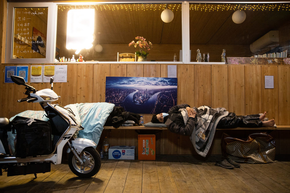 ↑4月20日午夜,在上海市武宁路桥下平房,因疫情封控无法回到小区的快递小哥在休息。