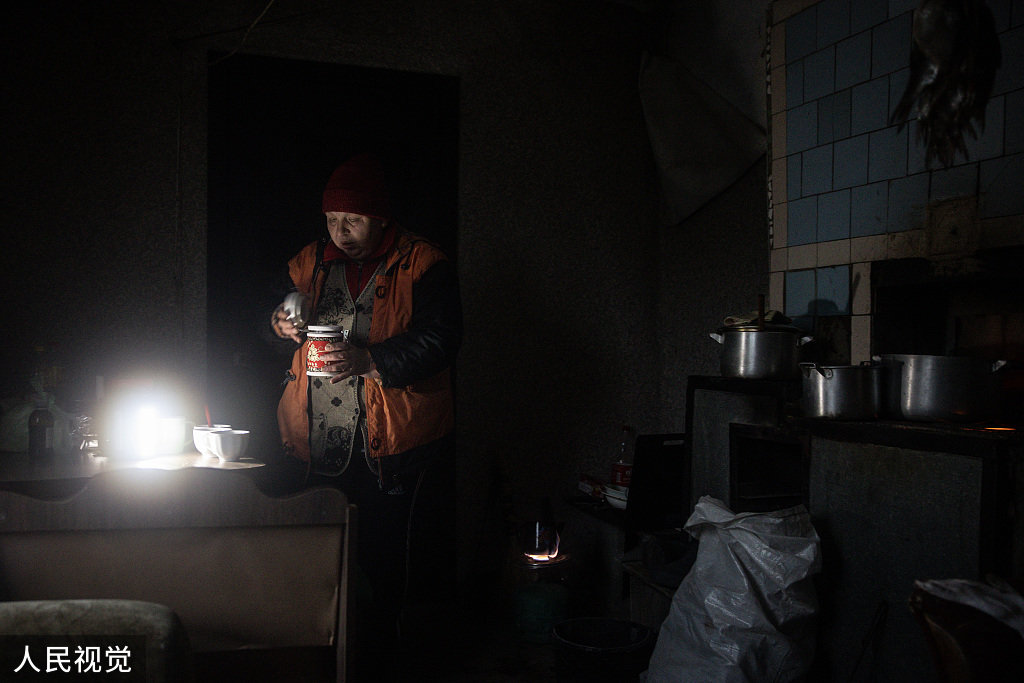 当地时间2022年11月30日，赫尔松地区，在郊区的Posad Pokrovske村，Olga Karepina在她被部分摧毁的房子里煮咖啡。