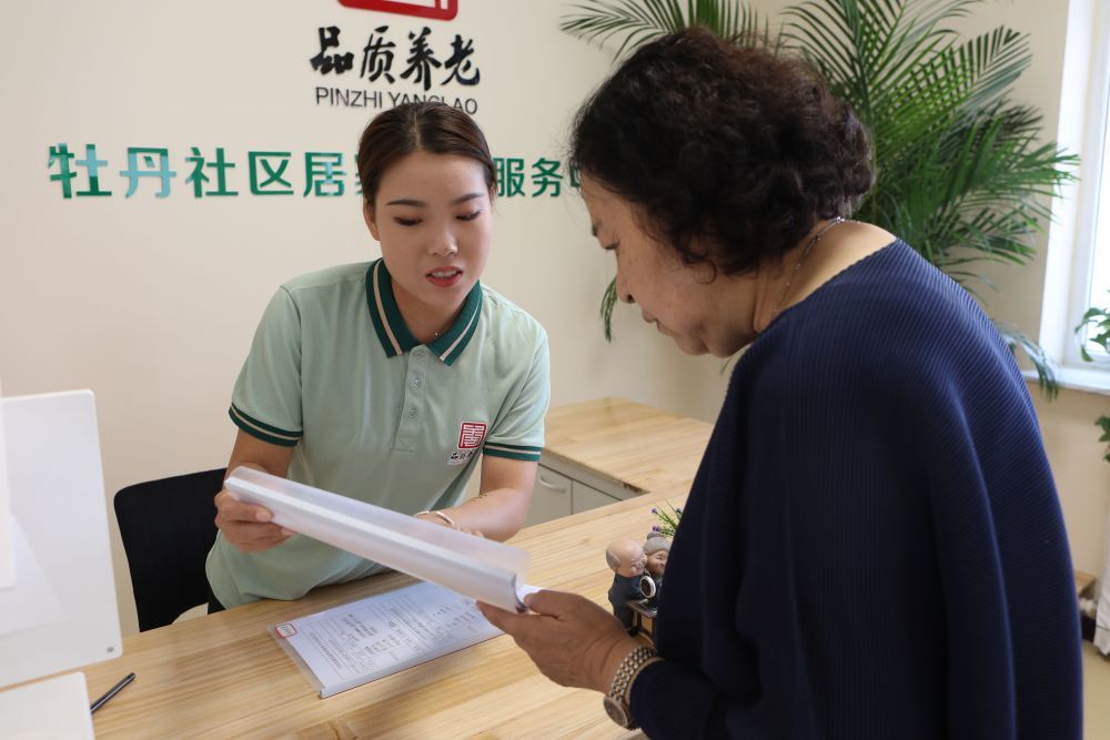 ↑8月18日，牡丹社区养老服务中心工作人员为就餐居民进行登记。