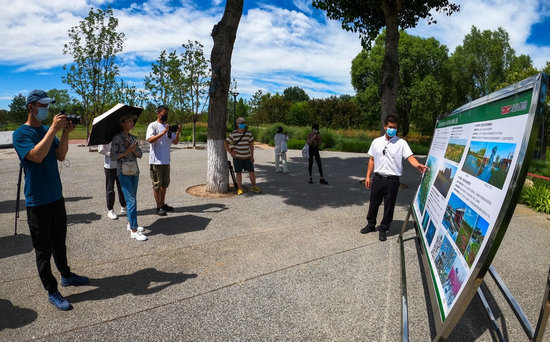 城市绿心森林公园工作人员为记者介绍园区情况/摄影 郑立文