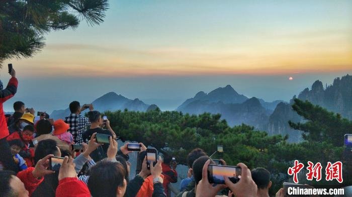 国庆假期第二天，游客在黄山之巅看日出。　 段雪峰　摄