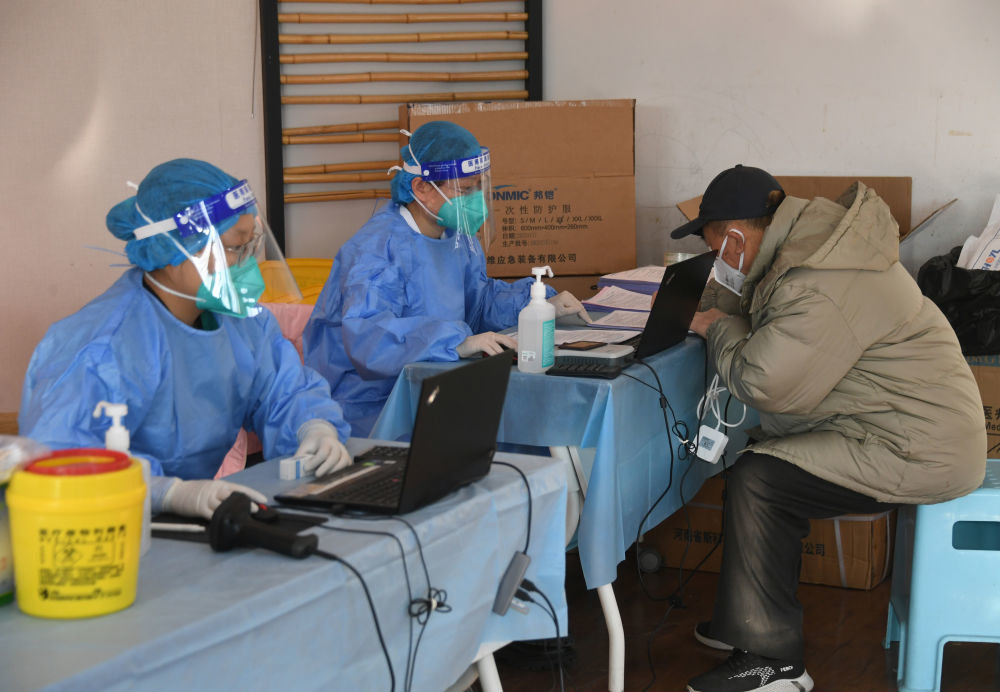 12月17日,在北京市海淀区田村路街道新冠疫苗临时接种点,医护人员为市民登记信息。